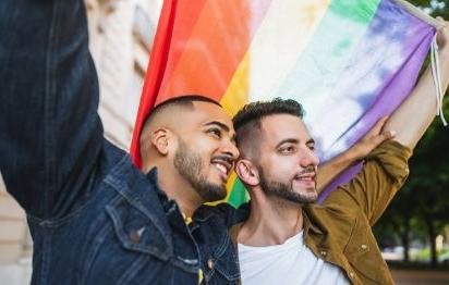 同性恋夫妇举着骄傲旗微笑