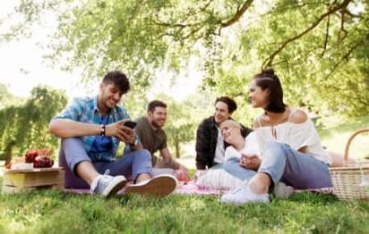 一家人在阳光明媚的绿色公园里野餐